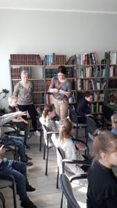 Na zdjęciu znajdują się uczestnicy zajęć. Dzieci siedzą na krzesłach. Zdjęcie wykonano w sali wielofunkcyjnej biblioteki.