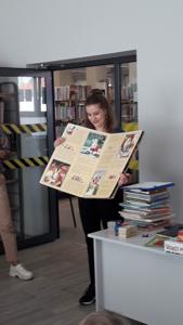Na zdjęciu znajdują się uczestnicy zajęć. Pani Bibliotekarka trzyma w ręce książkę.