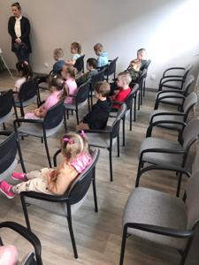 Na zdjęciu znajdują się uczestnicy zajęć. Dzieci siedzą na krzesłach. Zdjęcie wykonano w bibliotece.