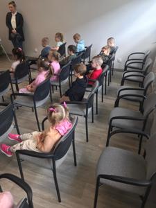 Na zdjęciu znajdują się uczestnicy zajęć. Dzieci siedzą na krzesłach. Zdjęcie wykonano w bibliotece.