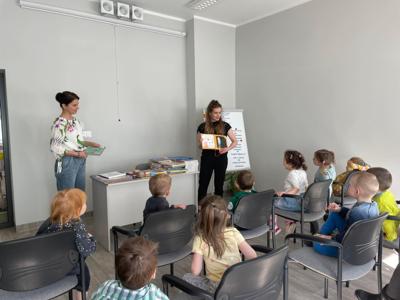 Na zdjęciu znajdują się uczestnicy pasowania. Dzieci siedzą na krzesłach. Zdjęcie wykonano w bibliotece.