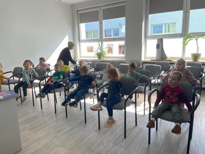 Na zdjęciu znajdują się uczestnicy pasowania. Dzieci siedzą na krzesłach. Zdjęcie wykonano w bibliotece.