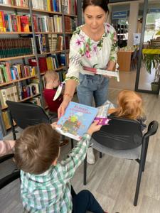 Na zdjęciu znajdują się uczestnicy pasowania. Dzieci siedzą na krzesłach. Zdjęcie wykonano w bibliotece.