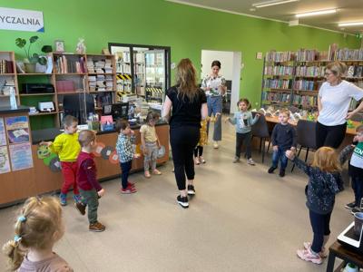 Na zdjęciu znajdują się uczestnicy pasowania. Dzieci stoją z kręgu. Zdjęcie wykonano w bibliotece.