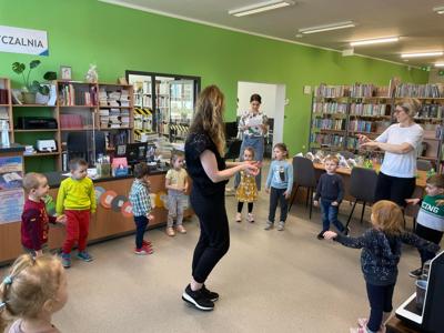Na zdjęciu znajdują się uczestnicy pasowania. Dzieci stoją z kręgu. Zdjęcie wykonano w bibliotece.