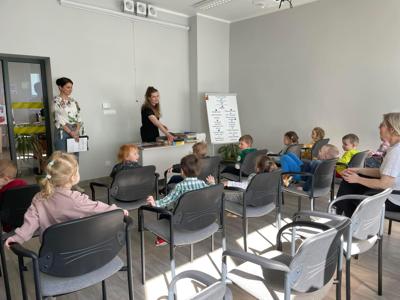Na zdjęciu znajdują się uczestnicy pasowania. Dzieci siedzą na krzesłach. Zdjęcie wykonano w bibliotece.