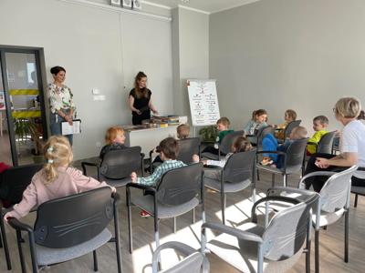Na zdjęciu znajdują się uczestnicy pasowania. Dzieci siedzą na krzesłach. Zdjęcie wykonano w bibliotece.