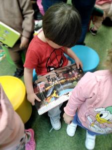 Na zdjęciu znajdują się uczestnicy warsztatów. Dzieci oglądają książki. Zdjęcie wykonano w bibliotece.ęcie wykonano w bibliotece.