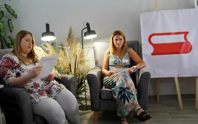 Na zdjęciu znajdują się uczestnicy czytający książkę siedząc na fotelach. Zdjęcie wykonano w bibliotece.