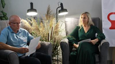 Na zdjęciu znajdują się uczestnicy czytający książkę siedząc na fotelach. Zdjęcie wykonano w bibliotece.