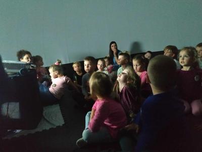 Na zdjęciu znajdują się uczestnicy kina sferycznego. Dzieci siedzą w kopule.