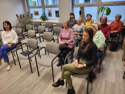 Na zdjęciu znajdują się uczestnicy spotkania autorskiego. Uczestnicy siedzą na krzesłach.