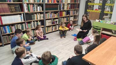 Na zdjęciu znajdują się uczestnicy zajęć. Dzieci siedzą na podłodze.