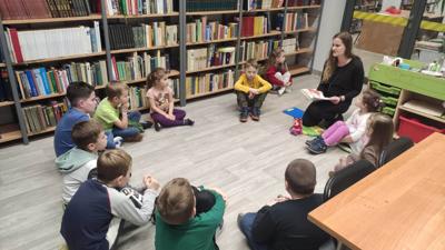 Na zdjęciu znajdują się uczestnicy zajęć. Dzieci siedzą na podłodze.