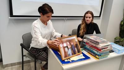 Na zdjęciu znajdują się uczestnicy wykładu. Młodzież siedzi na krzesłach. Prelegentki wyświetlają prezentacje multimedialną.