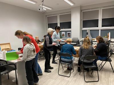 Na zdjęciach znajdują się uczestnicy warsztatów. Uczestnicy siedzą i wykonują rękodzieło.