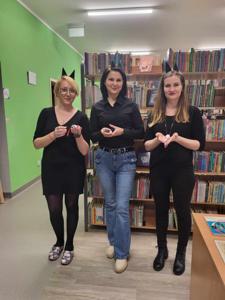 Na zdjęciu znajdują się pracownicy biblioteki. Kobiety trzymają w rękach myszki. W tle księgozbiór biblioteki.