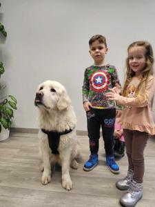 Na zdjęciu zgadują się uczestnicy zajęć. Na zdjęciu znajduje się pies.