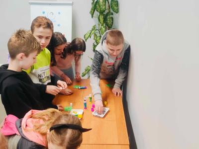 Zdjęcie przedstawia uczestników lekcji bibliotecznej.