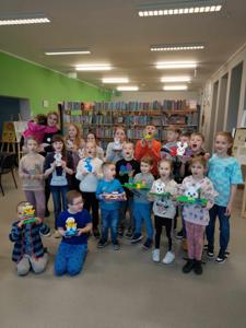 Zdjęcie przestawia uczestników warsztatów lego. Zdjęcie wykonano w bibliotece.