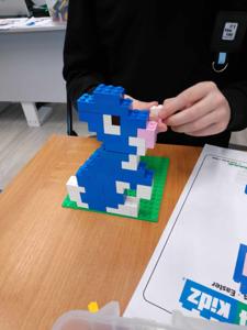 Zdjęcie przedstawia budowlę z klocków lego. Zdjęcie wykonano w bibliotece.