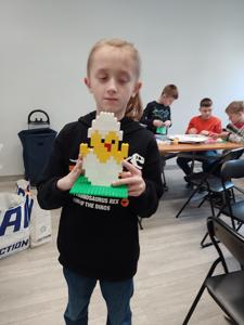 Zdjęcie przestawia uczestników warsztatów lego. Zdjęcie wykonano w bibliotece.
