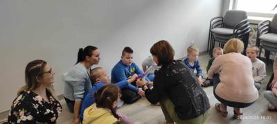 Zdjęcie przedstawia uczestników lekcji bibliotecznej. Zdjęcie wykonano w bibliotece.