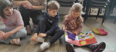 Zdjęcie przedstawia uczestników lekcji bibliotecznej. Zdjęcie wykonano w bibliotece.