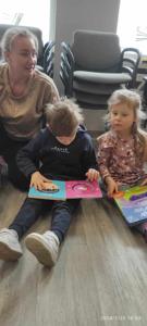 Zdjęcie przedstawia uczestników lekcji bibliotecznej. Zdjęcie wykonano w bibliotece.