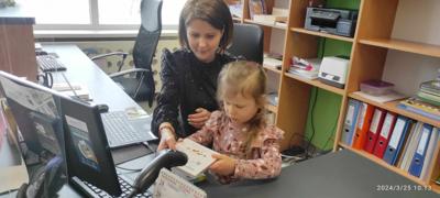 Zdjęcie przedstawia uczestników lekcji bibliotecznej. Zdjęcie wykonano w bibliotece.