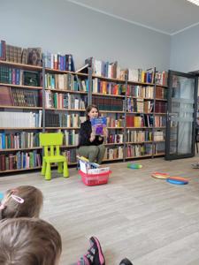 Zdjęcie przedstawia uczestników lekcji bibliotecznej. Zdjęcie wykonano w bibliotece.