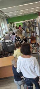 Zdjęcie przedstawia uczestników lekcji bibliotecznej. Zdjęcie wykonano w bibliotece.