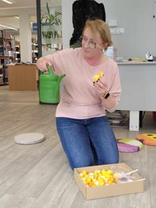 Zdjęcie przedstawia uczestników lekcji bibliotecznej. Zdjęcie wykonano w bibliotece.