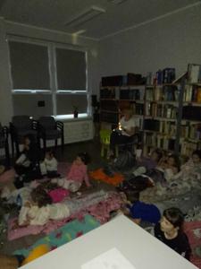 Zdjęcie przedstawia uczestników kina w bibliotece. Dzieci oglądają bajkę. Zdjęcie wykonano w bibliotece.