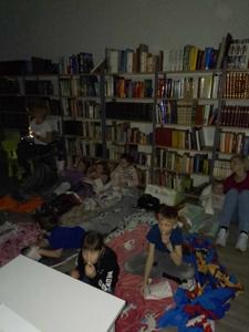 Zdjęcie przedstawia uczestników kina w bibliotece. Dzieci oglądają bajkę. Zdjęcie wykonano w bibliotece.