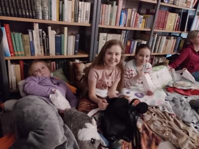 Zdjęcie przedstawia uczestników kina w bibliotece. Dzieci oglądają bajkę. Zdjęcie wykonano w bibliotece.