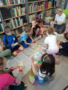 Zdjęcie przedstawia uczestników warsztatów bibliotecznych o tematyce ogrodniczej.  Zdjęcie wykonano na terenie biblioteki.