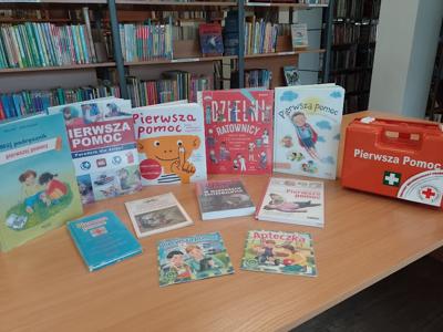 Na zdjęciu znajdują się książki o tematyce pierwszej pomocy. Zdjęcie wykonano w bibliotece.