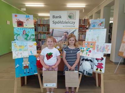 Na zdjęciu znajdują się dzieci nagrodzone w konkursie plastycznym i literackim. Zdjęcie wykonano w  bibliotece.