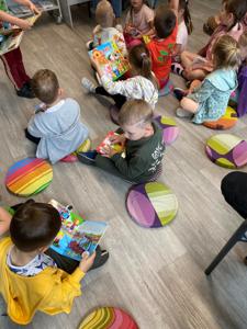 Na zdjęciu znajdują się uczestnicy lekcji bibliotecznej.  Zdjęcie wykonano w bibliotece.