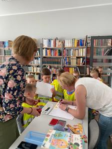 Na zdjęciu znajdują się uczestnicy lekcji bibliotecznej.  Zdjęcie wykonano w bibliotece.