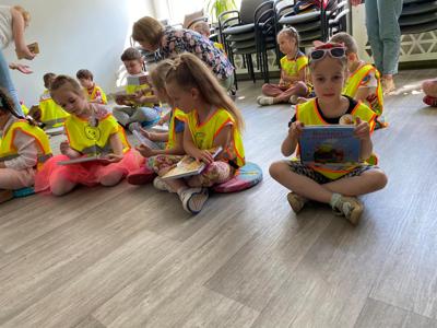 Na zdjęciu znajdują się uczestnicy lekcji bibliotecznej.  Zdjęcie wykonano w bibliotece.