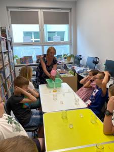 Zdjęcie przedstawia uczestników zajęć eksperymentu w bibliotece.