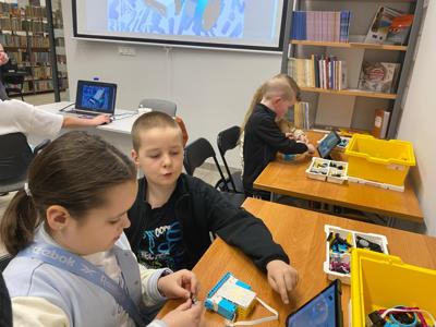 Zdjęcie przestawia uczestników zajęć Zabawa i Programowanie. Zdjęcie wykonano w Bibliotece.