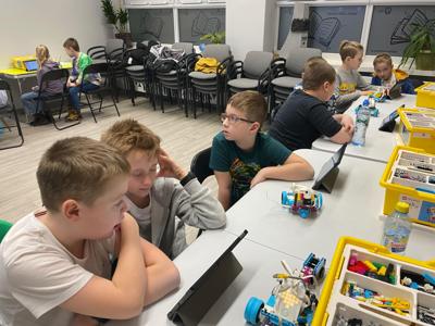 Zdjęcie przestawia uczestników zajęć Zabawa i Programowanie. Zdjęcie wykonano w Bibliotece.