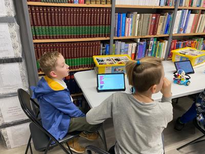 Zdjęcie przestawia uczestników zajęć Zabawa i Programowanie. Zdjęcie wykonano w Bibliotece.