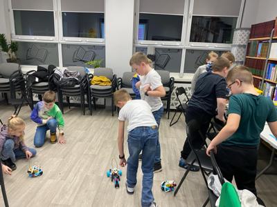 Zdjęcie przestawia uczestników zajęć Zabawa i Programowanie. Zdjęcie wykonano w Bibliotece.