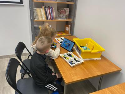 Zdjęcie przestawia uczestników zajęć Zabawa i Programowanie. Zdjęcie wykonano w Bibliotece.