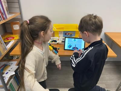 Zdjęcie przestawia uczestników zajęć Zabawa i Programowanie. Zdjęcie wykonano w Bibliotece.