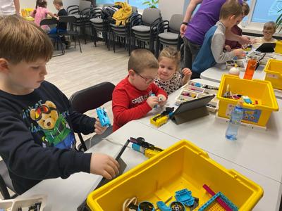 Zdjęcie przestawia uczestników zajęć Zabawa i Programowanie. Zdjęcie wykonano w Bibliotece.